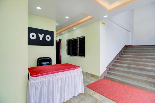 a room with stairs and a table with a red rug at SPOT ON RISA PALACE in Bhutiāgāon