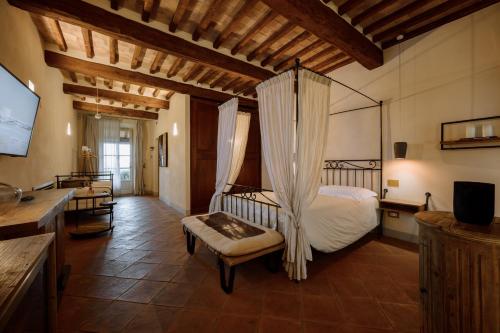a bedroom with a bed with a hanging bedvisor at Capanna Suites in Montalcino
