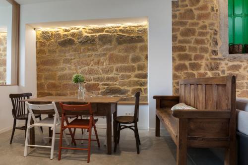 a dining room with a stone wall and a table and chairs at Casa la Devesa de Sanabria in Remesal