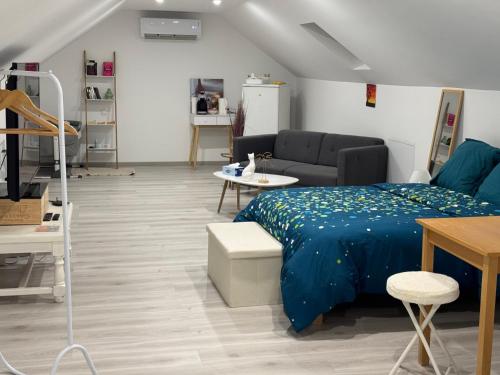 a living room with a bed and a couch at Chez Julie in Cepoy
