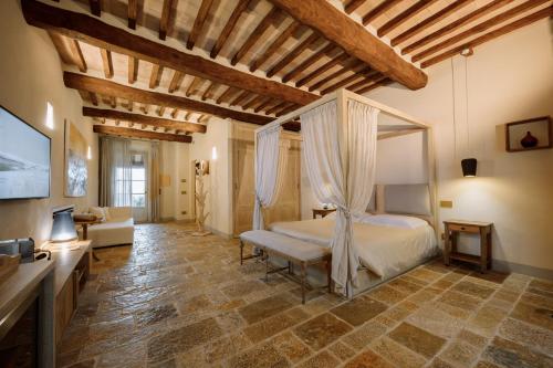 a bedroom with a canopy bed and a living room at Capanna Suites in Montalcino