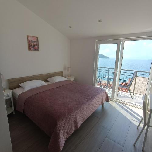 a bedroom with a bed and a view of the ocean at Apartmani Kristijan in Igrane