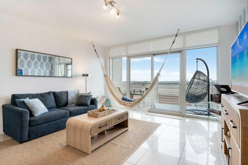 a living room with a couch and a hammock at Palm Place Heart of Miami with Parking Pool and Gym in Miami