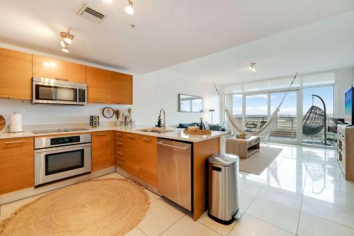 a kitchen with wooden cabinets and stainless steel appliances at Palm Place Heart of Miami with Parking Pool and Gym in Miami
