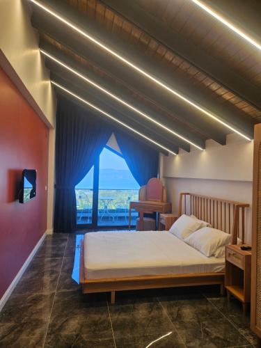 a bedroom with a large bed with a large window at Sapancamodern 2 in Sapanca