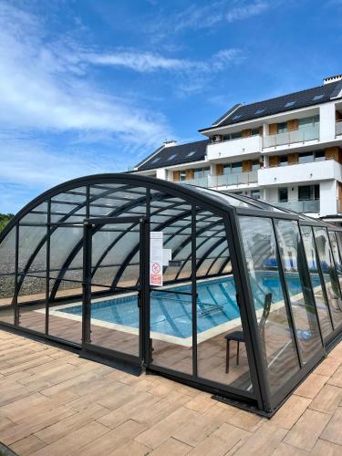 a glass bridge over a swimming pool in front of a building at BALTIC SUN in Sztutowo