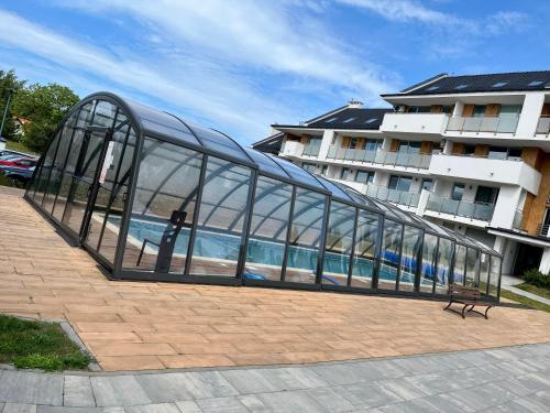 a glass building with a bench in front of a building at BALTIC SUN in Sztutowo