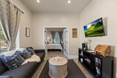 a living room with a couch and a tv at Upscale 1890s Historic Apartment in Sacramento