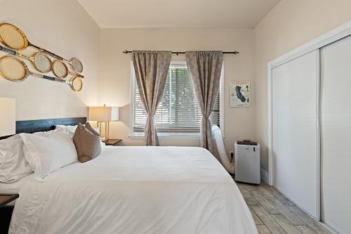 a bedroom with a large white bed and a window at Upscale 1890s Historic Apartment in Sacramento
