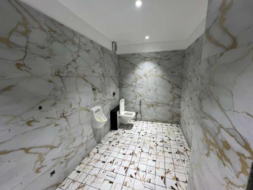 a bathroom with marble walls and two urinals at hotel shree palace in Ratlām
