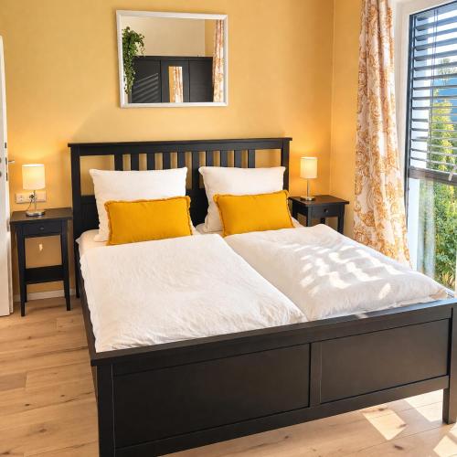 a bedroom with a bed with two yellow pillows at Apartment im schönen Taunus in Dickschied