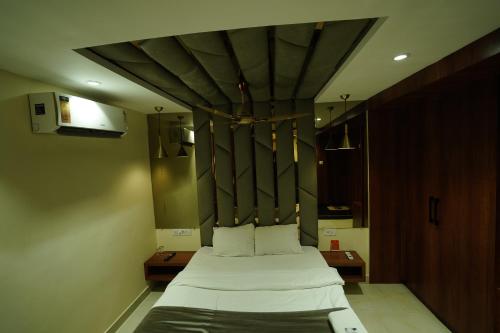 a bedroom with a large bed with white sheets at hotel shree palace in Ratlām