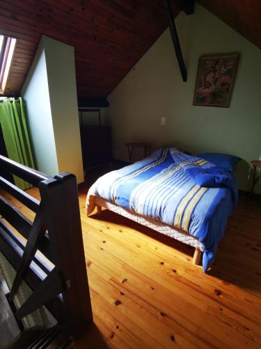 a bedroom with a bed and a wooden floor at Gîtes & chambre d'Hôtes - AVEZE in Avèze