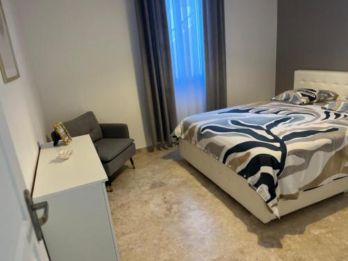 a small bedroom with a bed and a chair at Katy in Nice