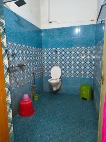 a bathroom with a toilet and a blue tiled floor at Hotel Parinay Vatika in Deoghar