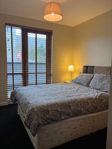 a bedroom with a large bed and a window at Courthouse View Penthouse 1 in Clifden