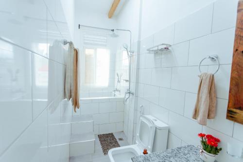 a white bathroom with a toilet and a shower at Jabulani Moshi in Msaranga
