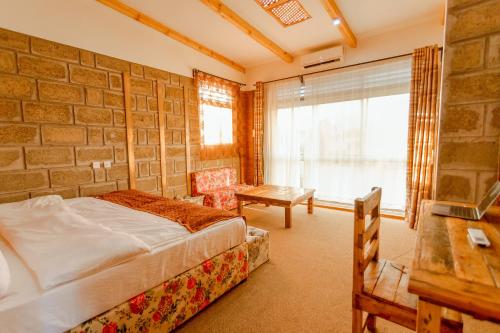 a bedroom with a bed and a brick wall at Jabulani Moshi in Msaranga