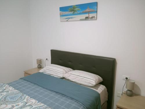 a bed with two pillows and a picture on the wall at paraiso soleado in Tazacorte