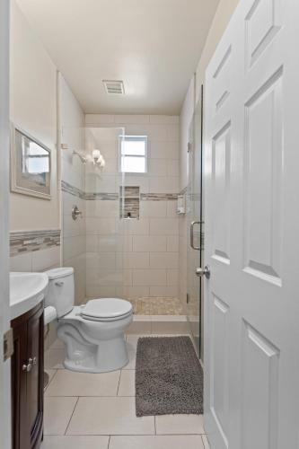 a white bathroom with a toilet and a sink at Marvelous Midtown Stay with a Modern Twist in Sacramento