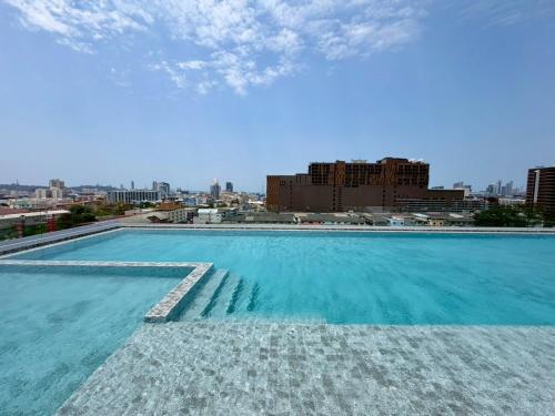 a large swimming pool with a city in the background at The Iconic in Pattaya