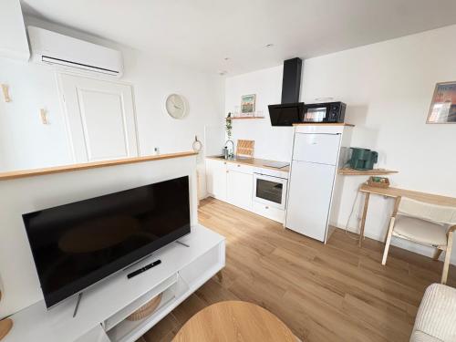 a living room with a large flat screen tv at Le Japandi Maison confortable et calme à Libourne in Libourne