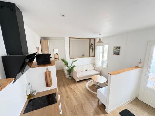 a white living room with a couch and a table at Le Japandi Maison confortable et calme à Libourne in Libourne