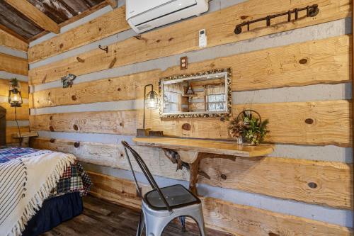 a bedroom with a wooden wall with a mirror at Creekside Treehouse in Cosby