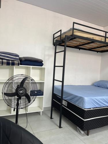 a room with two bunk beds and a fan at Kitnet aconchegante próximo a unesp in Botucatu