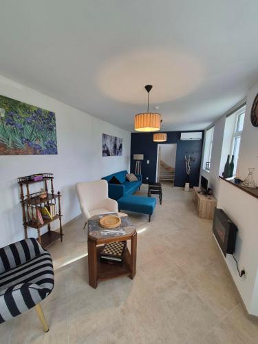 a living room with a blue couch and a table at Le Fond du Village in Solre-Saint-Géry