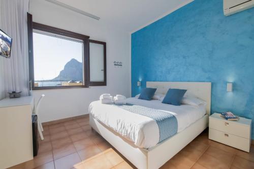 a bedroom with a large bed with a blue wall at Il Torrazzo da Francesca in San Vito lo Capo