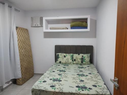 a small bedroom with a bed with a floral bedspread at Eloá Mar's Corner in Angra dos Reis