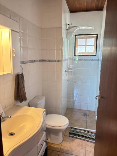 a bathroom with a sink and a toilet and a shower at Micas House in Ilhabela