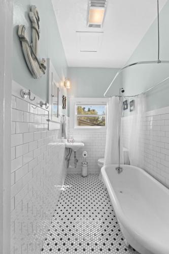 a white bathroom with a tub and a sink at Historic Charm with Parking in Center of Midtown in Sacramento
