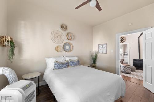 a white bedroom with a bed and a chair at Historic Charm with Parking in Center of Midtown in Sacramento