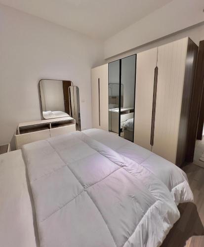 a white bedroom with a large bed and a mirror at دقيقه للبحيره أقامه فندقيه مدينتي بريفادو madinaty privado in Madinaty