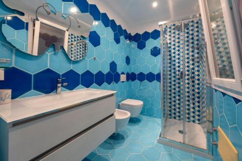 a blue bathroom with a sink and a toilet at Smeraldo in Palau
