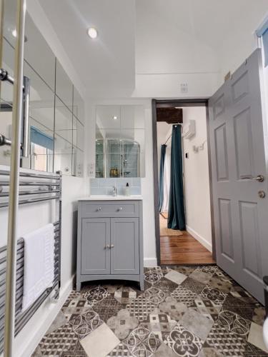 a bathroom with a sink and a mirror and a door at Stylish Loft in Stockport - Free Parking - 10 min to Manchester - Flat 1 in Stockport