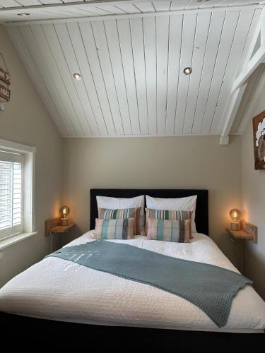 a bedroom with a large bed with two night stands at Beach House Texel in De Koog