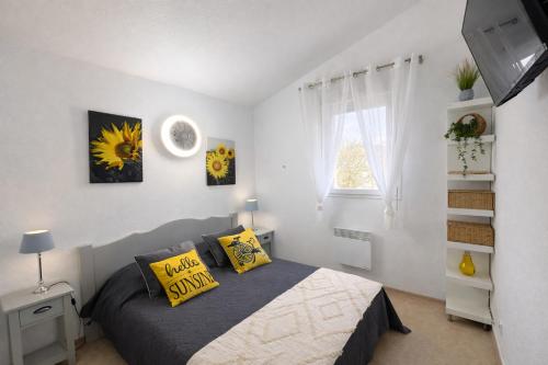 a bedroom with a bed with yellow pillows and a window at Résidence Les Demeures du Ventoux in Aubignan