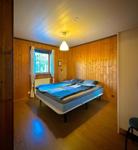 a bedroom with a bed in a room with wooden walls at Barts house in Länshult