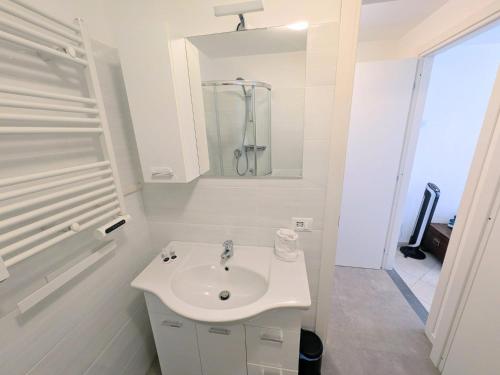 a white bathroom with a sink and a shower at Back in Tide , frontal sea view window, no AC, Pet friendly in Riomaggiore