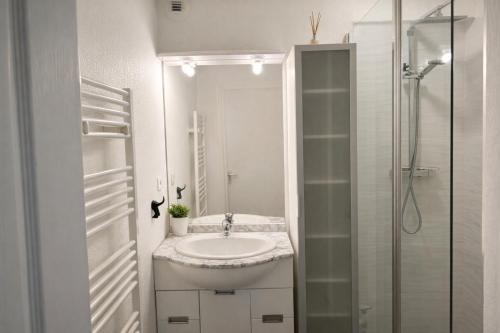 a white bathroom with a sink and a shower at Résidence Les Demeures du Ventoux in Aubignan