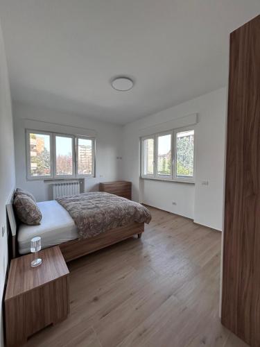 a bedroom with a bed and a table and windows at Nuvola Hosting in Segrate