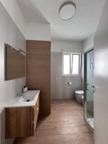 a bathroom with a sink and a toilet and a mirror at Nuvola Hosting in Segrate