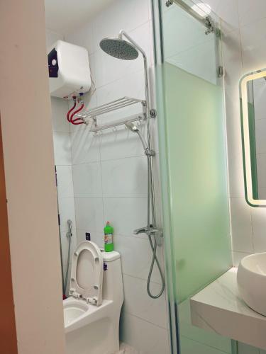 a bathroom with a shower and a toilet and a sink at Êm Attic Hai Phong Old Town in Hai Phong