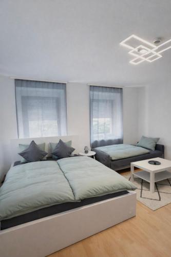 a white bedroom with a bed and a couch at Ferienwohnung LAZ am Dreiländereck in Bad Säckingen