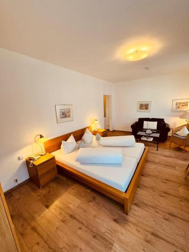 a bedroom with a large bed and a living room at Kaiserstühler-Hof in Breisach am Rhein