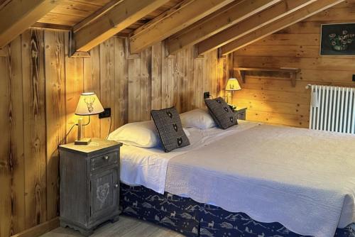 ein Schlafzimmer mit einem Bett in einer Blockhütte in der Unterkunft Hotel Letterario Locanda Collomb in La Thuile