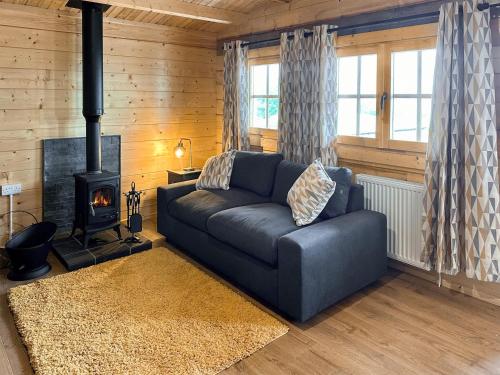 a living room with a couch and a fireplace at Wind Hall Log Cabin in Gosforth